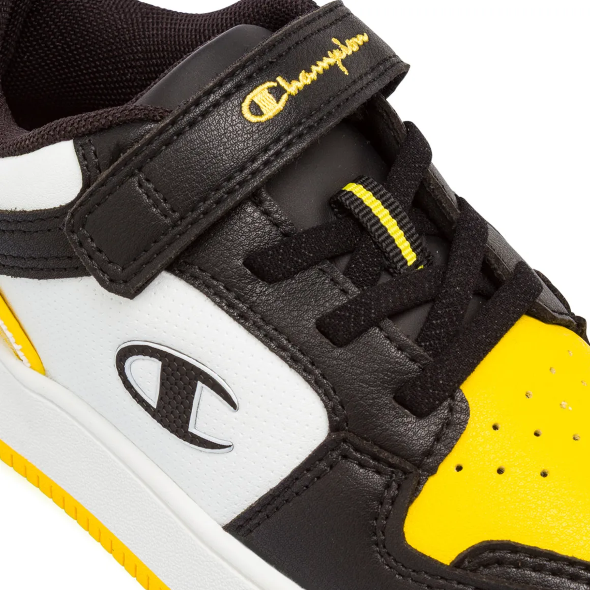 Sneakers bicolore bianco e nero con inserti gialli da Bambino Champion